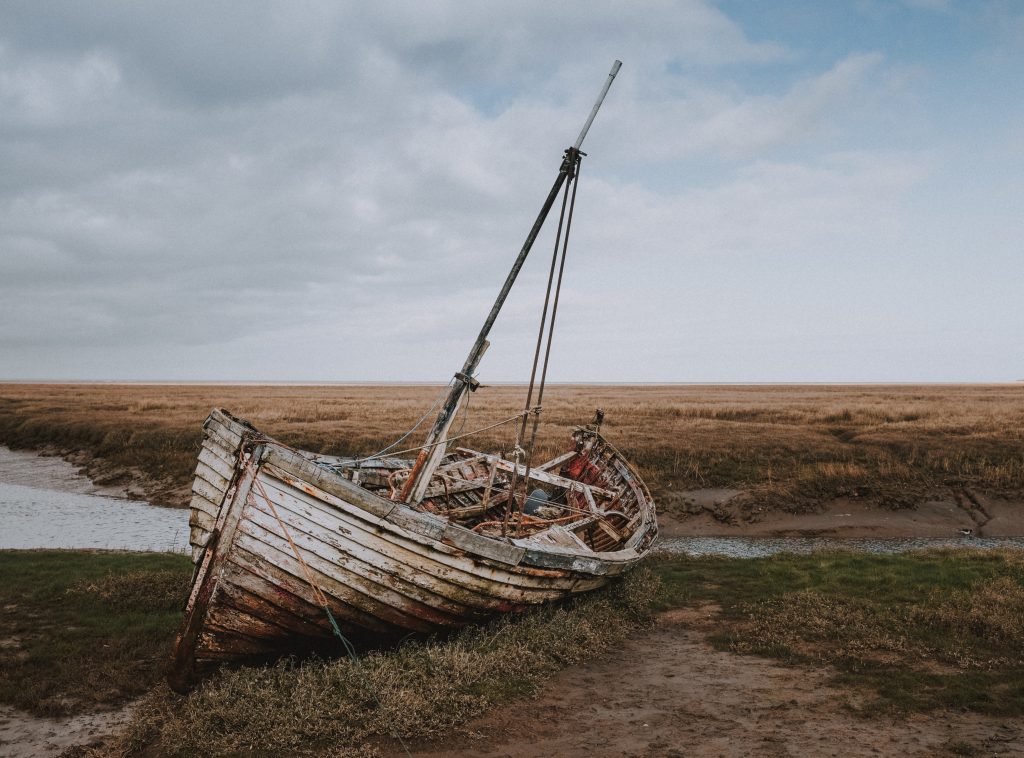 broken boat by the riverbank