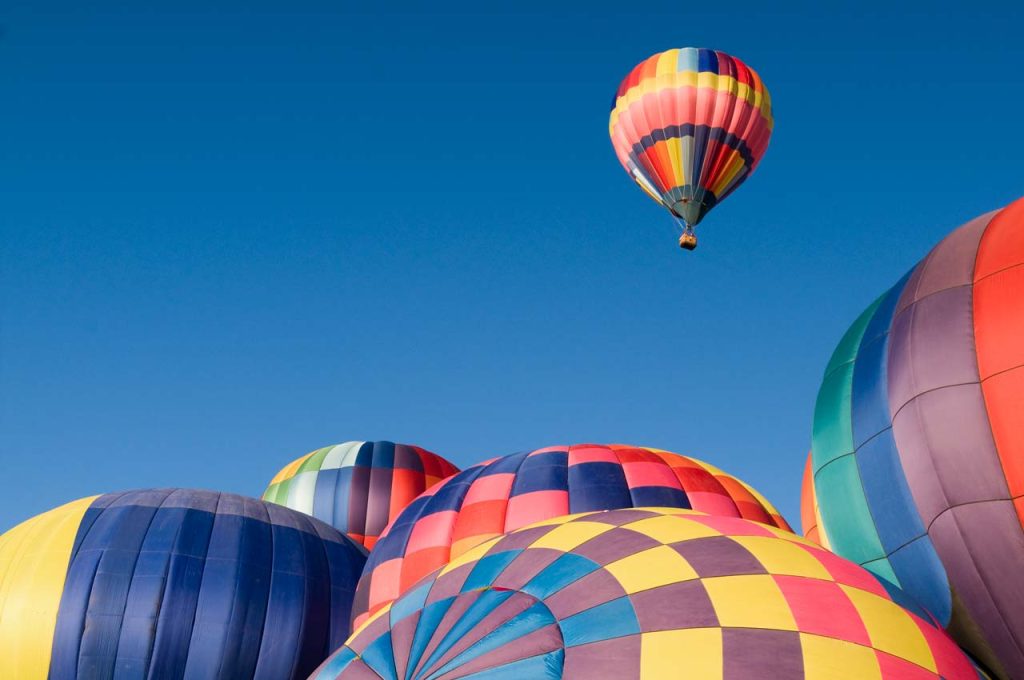 one hot air balloon flying above many others