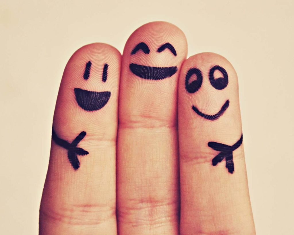 fingers with smiley faces drawn on them